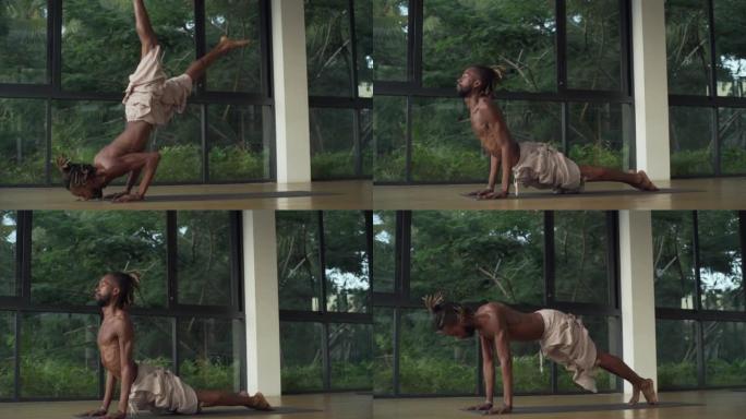 非洲裔男子在日出时在工作室练习倒立瑜伽姿势快速慢动作