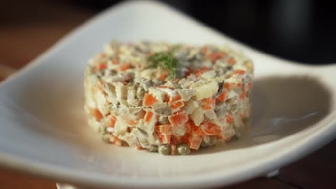 传统的俄罗斯新鲜奥利维尔沙拉躺在木桌上