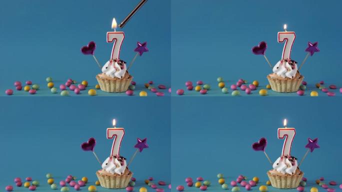 祝7岁的孩子生日快乐，生日蛋糕，蜡烛和蓝色背景上的生日装饰品。复制空间。放置文本