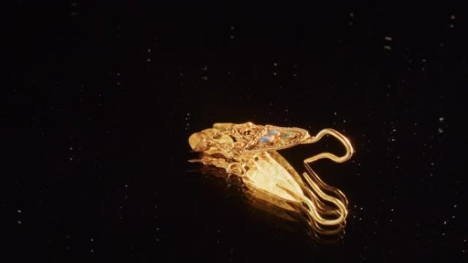 一个2000岁的斯基泰女祭司的金耳环，一个在挖掘过程中发现的旧耳环，纺车。复古珠宝。宗教。特写