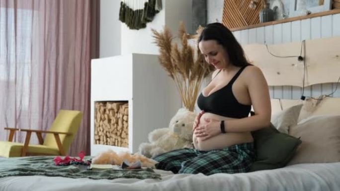 孕妇坐在床上摸肚子