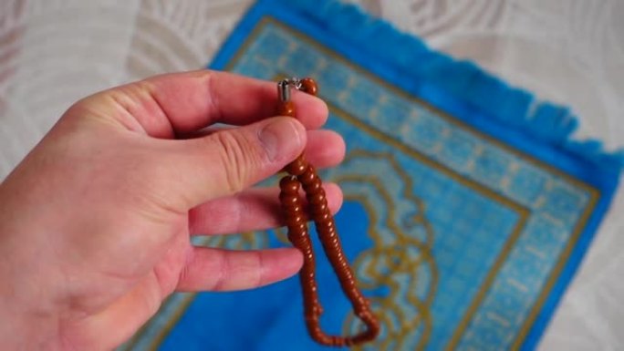 房子里有一个穆斯林的蓝色祈祷地毯，他的念珠，旁边是一个祈祷地毯，用于伊斯兰教的礼拜，