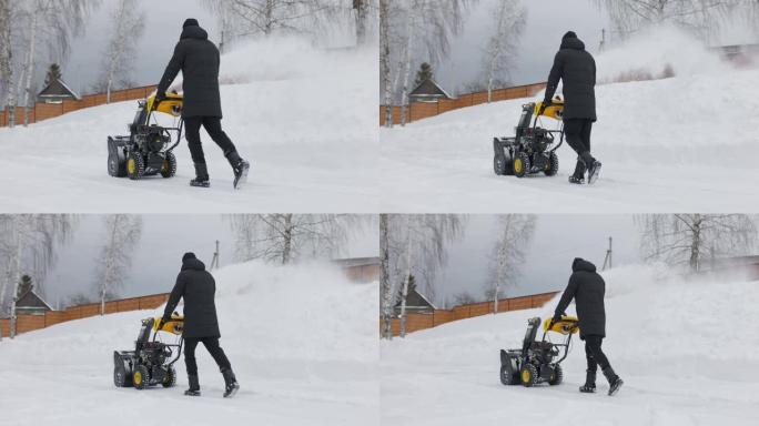 一名男子在慢动作的降雪中，用吹雪机在院子里扫雪