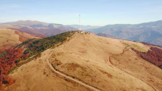 一架无人机在山顶上的电信天线旁边飞行。