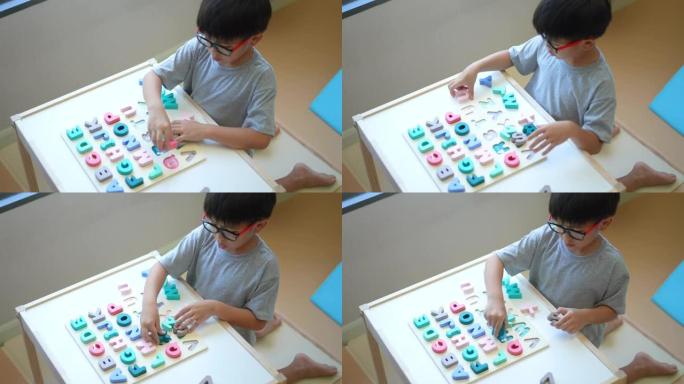 亚洲男孩学习英语字母，玩具和字母。返校的概念