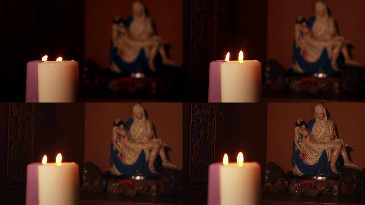 2017年3月13日，雅加达: 两支燃烧的蜡烛的视频片段，背景上有一个Pieta雕像