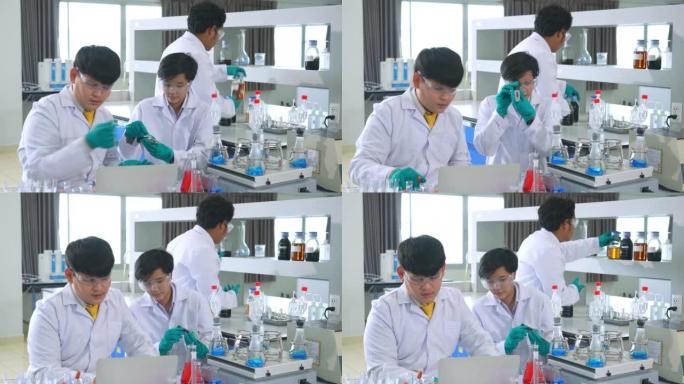 一组亚洲医学科学家研究人员穿着实验室外套和防护设备，在寻找潜在的新型冠状病毒肺炎疫苗时，仔细检查，测