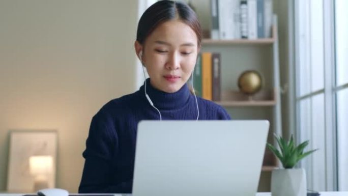 年轻的亚洲女性创作者通过笔记本电脑在家中谈论视频电话会议或虚拟会议