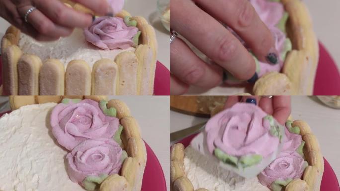 一个女人用和风玫瑰装饰蛋糕。萨瓦亚迪饼干和棉花糖玫瑰蛋糕。特写。