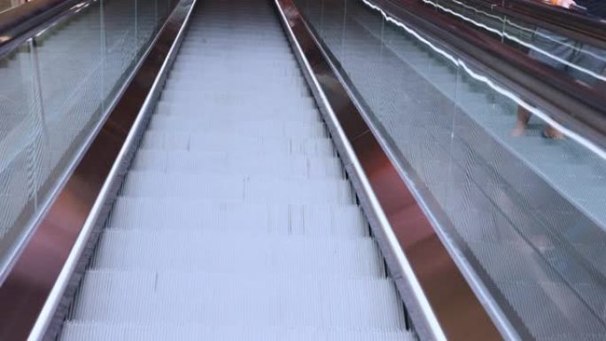 近距离慢动作4k的金属自动扶梯正在百货商店或火车站的上层移动，并带有美丽的阳光，它显示了城市生活的交