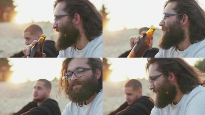 在侧面可以看到一个戴着眼镜的长发和浓密胡须的男人的脸男孩正在从玻璃瓶中喝啤酒，并与坐在外面的背景光线