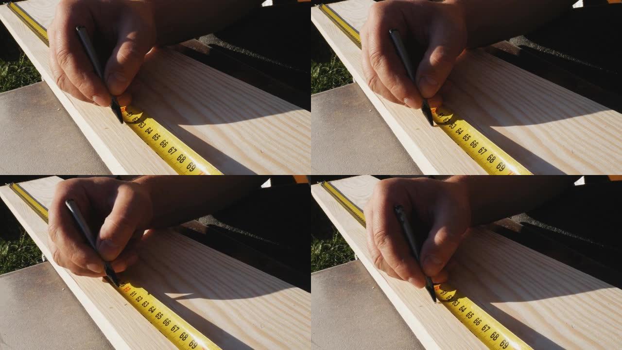 工人用尺子用铅笔标记尺寸。黄色卷尺，卷尺。为后续处理准备板的尺寸