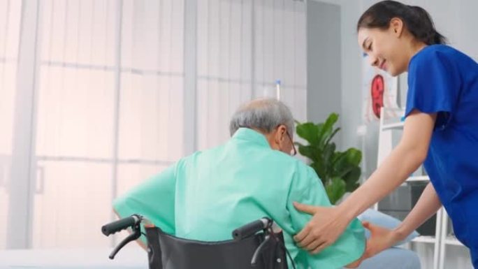 亚洲年轻女性治疗师在医院支持老年患者。有吸引力的女性专科医生在预约期间为老年成熟男性进行物理治疗。