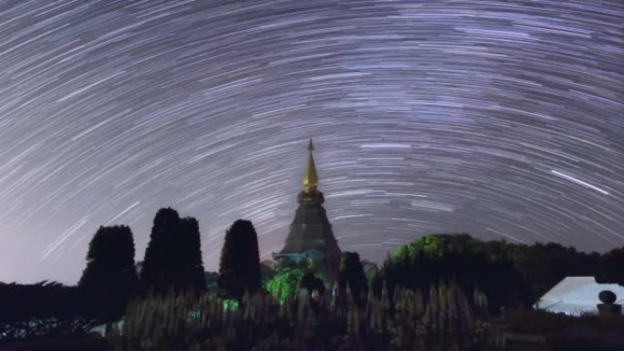 延时4K的星光轨迹移动在一个神圣的寺庙在Doi Inthanon国家公园，泰国清迈。黑夜从黑夜转到白