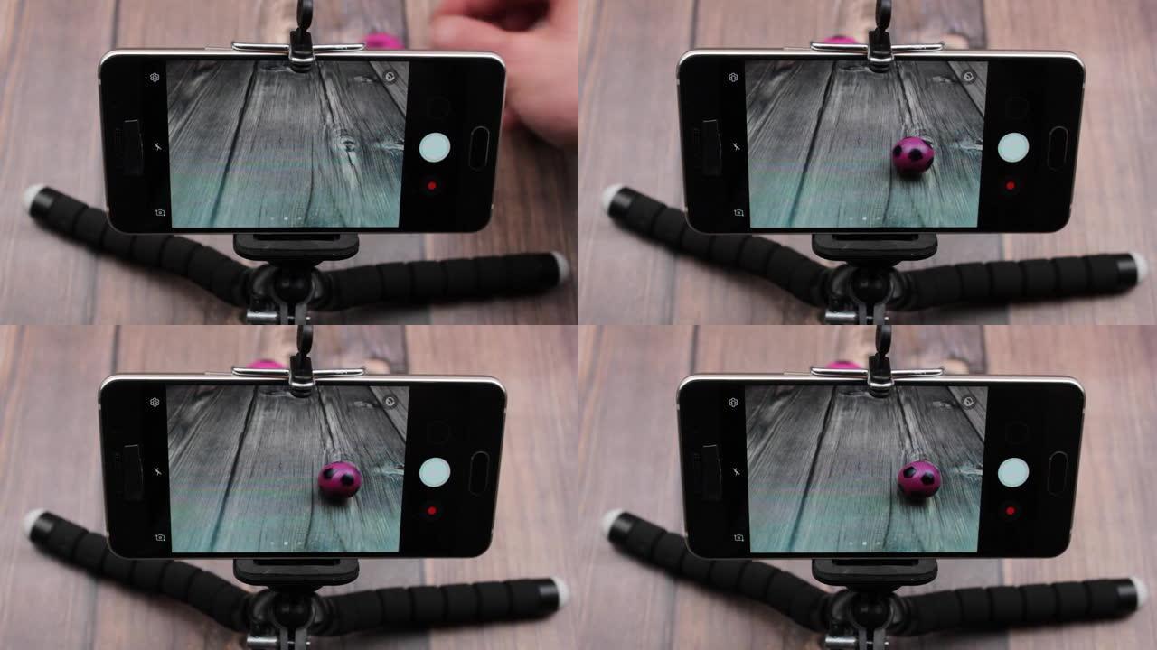 智能手机通用黑色塑料三脚架。用三脚架在智能手机上拍摄。
