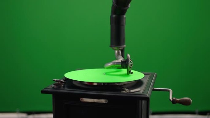 老式留声机。老式旧留声机在绿屏背景下播放黑胶唱片。木箱转盘。乙烯基留声机。慢动作在阿瑞·阿列克谢电影