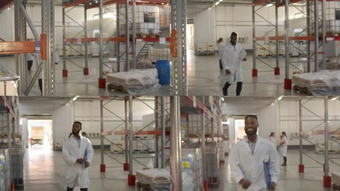 快乐的非洲工厂工程师跳舞，微笑地走在仓库里
