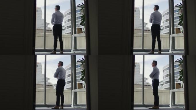 4k视频片段，一个成熟的商人在现代办公室里若有所思地看着窗外