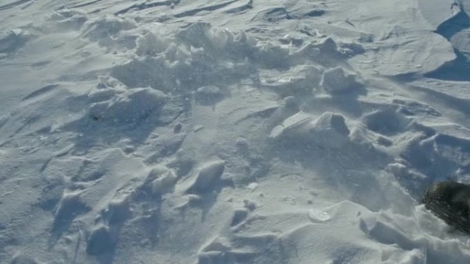 一个男人走在冰天雪地上。靴子踢到雪。美丽的冬天的风景。俄罗斯的自然地标。前视图。慢动作