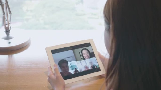 女人使用数字平板电脑和手机与家人进行社交电话会议