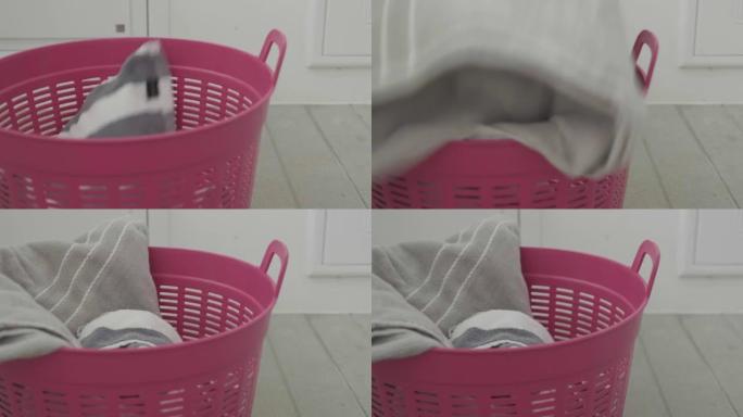 肖像脏衣服掉进粉红色的洗衣篮
