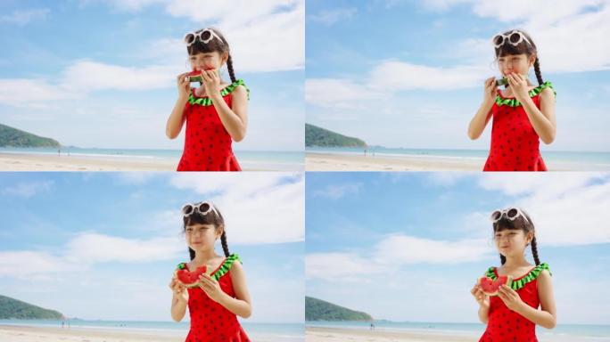 穿着泳衣的4k亚洲小女孩在夏天阳光明媚的日子里在海滩上玩耍时吃西瓜。