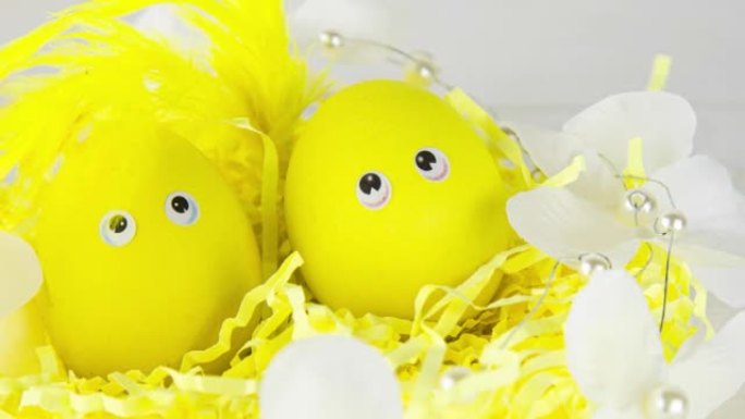 装饰有黄色鸡蛋的篮子在阳光下装饰有羽毛