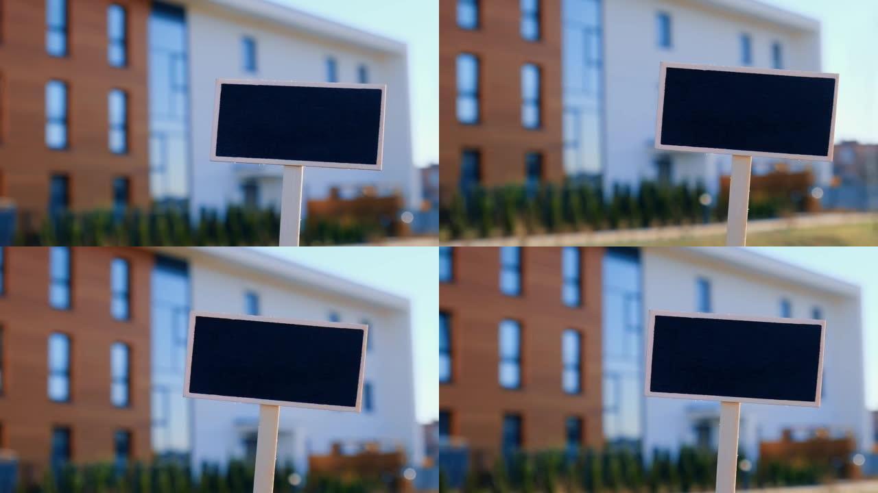空白黑色广告牌反对新公寓楼空样机模板黑板标签房屋出租。待售公寓。在新家前签名。广告