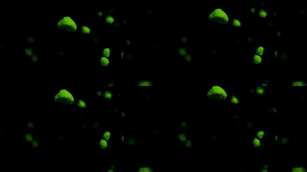 绿色体积荧光颗粒在黑色移动背景上移动和变化，过渡。