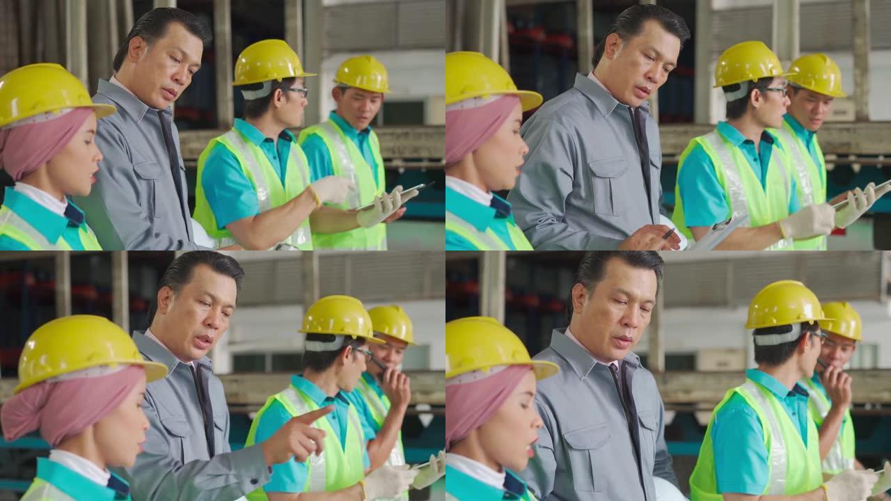 亚洲工厂经理与他的团队一起在仓库中处理清单和仓库中的装运订单