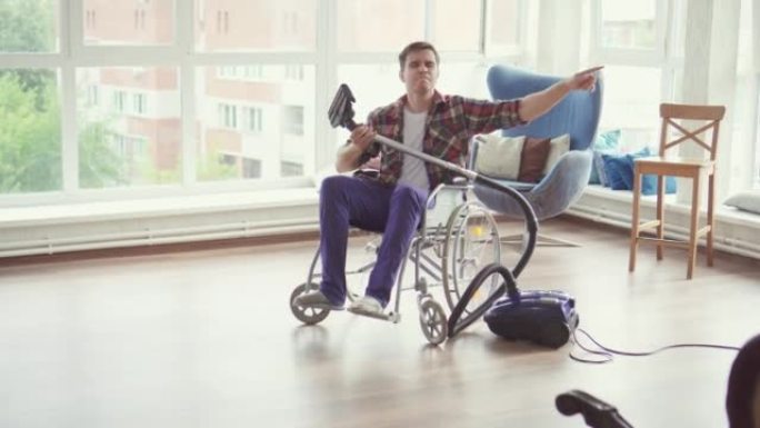 一个坐在轮椅上的兴高采烈的人正在家里用吸尘器打扫