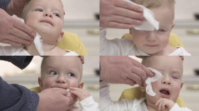 父亲在厨房喂他后，用婴儿湿巾擦着他一岁儿子的脸。