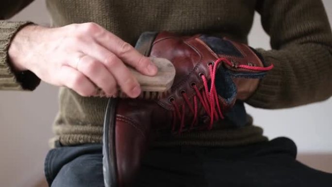 高加索男性抛光棕色皮靴鞋用软刷打蜡后，用擦鞋蜡浸渍