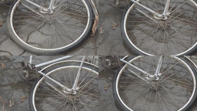 一辆旧的脏自行车的轮子被水柱冲洗了。