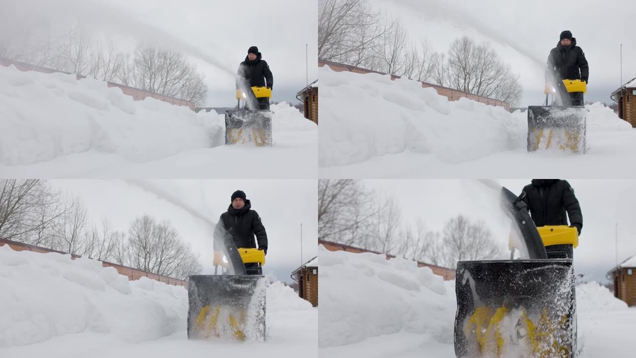 男子在院子里用机械扫雪机除雪。雪粉。慢动作