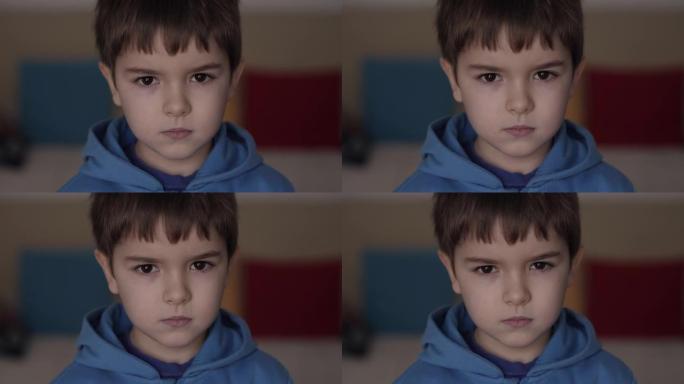 年轻严肃的男孩在室内看着相机。肖像可爱的学龄前儿童严重的沉思担心高加索青少年。悲伤自信的小男孩。人脸