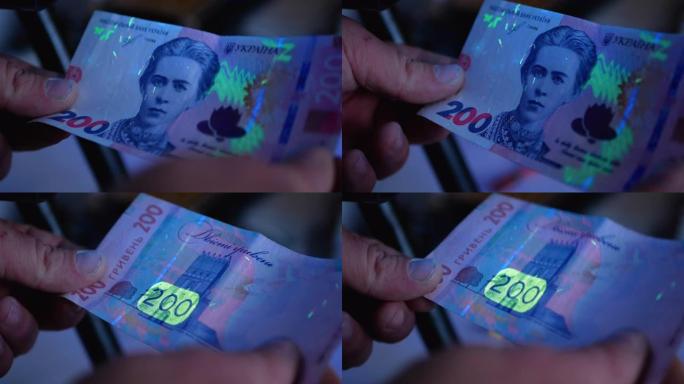 200 hryvnas莳萝在紫外线灯下。货币支票