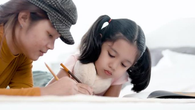 4k 50fps快乐的兄弟姐妹帮助可爱的幼儿园孩子一起在床上画画和玩耍。用彩色铅笔在纸上画画。快乐概