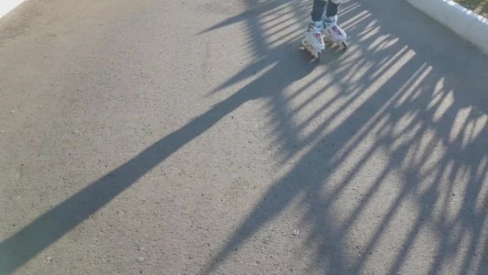 夏天，两个姐妹在公园散步。姐姐穿着旱冰鞋，妹妹手里拿着糖果追赶她。快乐的童年