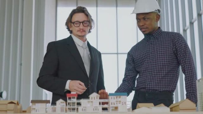 两位男建筑师同意建筑模型的细节。