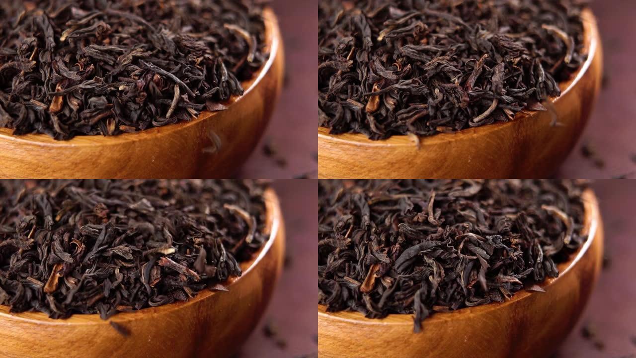 棕色木制乡村碗干红茶。慢动作落下的干叶。宏
