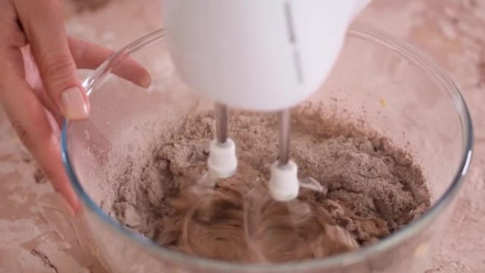 制作巧克力蛋糕的逐步过程。在搅拌碗中搅拌可可面团。