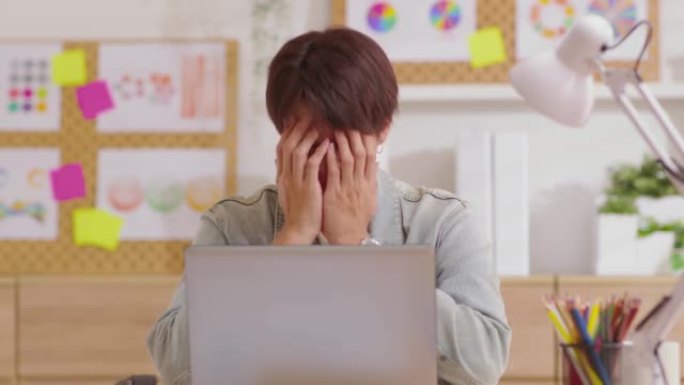 紧张的年轻人因肌肉紧张而头痛，在计算机上工作时偏头痛。疲惫的工人在家庭办公室被任务压得喘不过气来。男