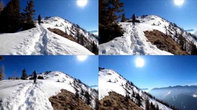 女人背着背包到达弗赖贝格的山顶十字路口，在奥地利卡林西亚的卡拉万克斯的白雪皑皑的山峰上享有风景。泽尔