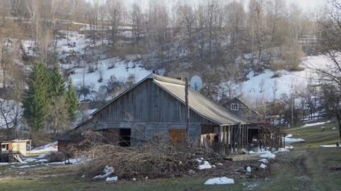 一座被白雪覆盖的山脉环绕的简易木屋。