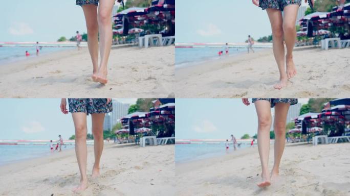 亚洲美丽的年轻女子旅行者赤脚在平静温暖的海浪中行走的特写镜头。迷人的快乐女孩在海滩上迈出一步时感到放