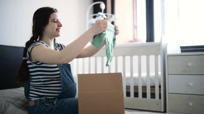 孕妇用婴儿服装打开包装。