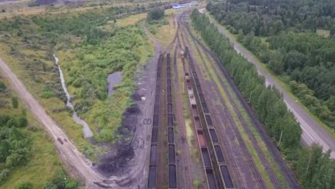 有轨电车煤炭运输，鸟瞰图。满载化石燃料煤的火车货车的移动，总体规划。