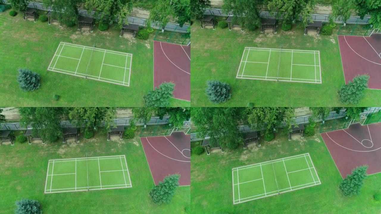 网球场空中俯视图。在美国城市公园的篮球场和网球场上升的空中射击，在晨光下，长长的阴影被无人机从上方捕