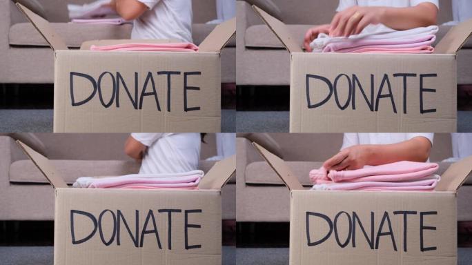 年轻女子把衣服放进家里的捐款箱里，帮助穷人。捐赠理念。